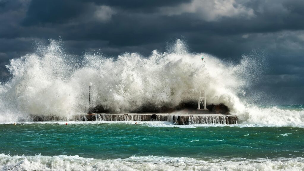 pexels-photo-826388-826388 Dramatic ocean waves crashing against a concrete structure in Pantanassa, capturing nature's raw power.